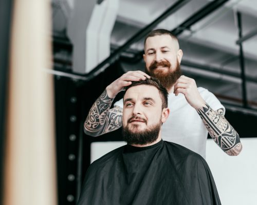 barber styling customer hair at barbershop