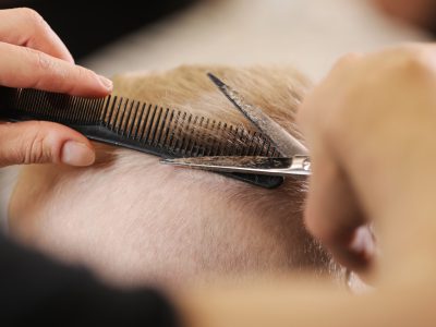 Men's hairstyling, haircutting, in a barber shop or hair salon.